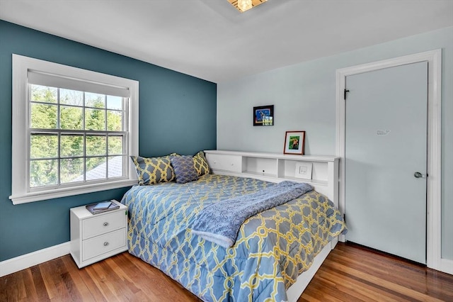 bedroom with wood finished floors and baseboards