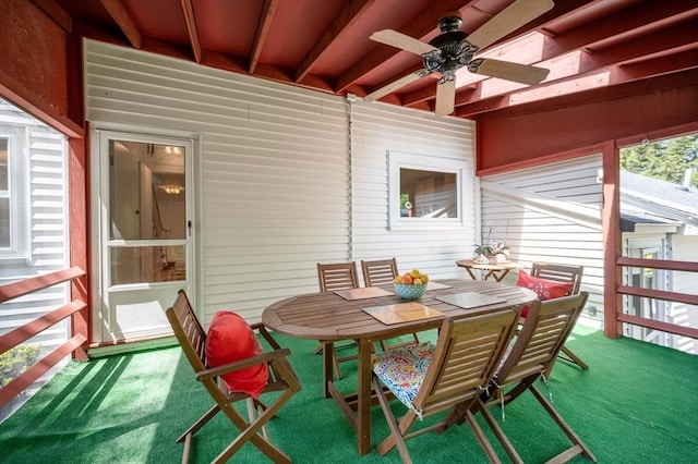 sunroom / solarium with ceiling fan and outdoor dining space