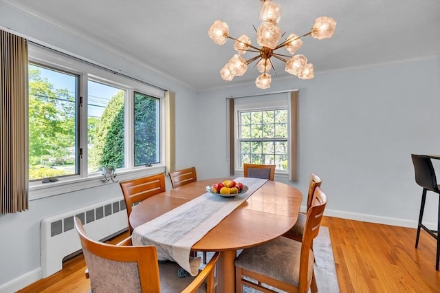 dining area featuring radiator heating unit, light wood finished floors, baseboards, a chandelier, and ornamental molding