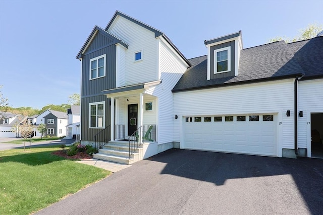 19 Millies Way, Sterling, MA 01564 - view of front of house featuring an attached garage, driveway, board and batten siding, a front yard, and a shingled roof