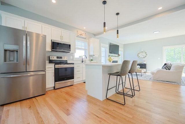 19 Millies Way, Sterling, MA 01564 - kitchen with stainless steel appliances, plenty of natural light, white cabinetry, open floor plan, and recessed lighting