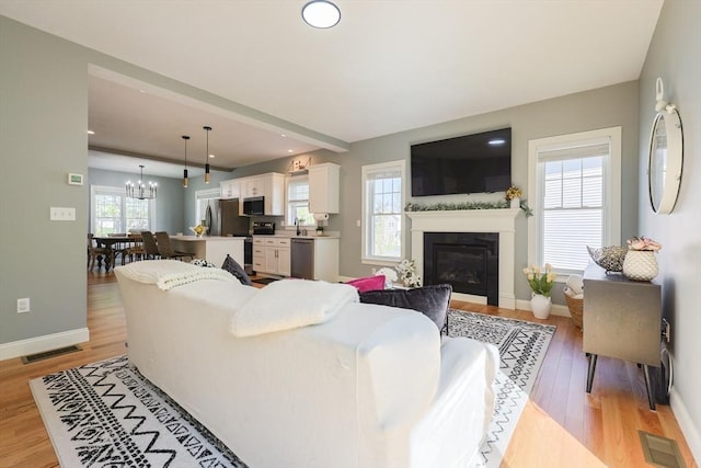 19 Millies Way, Sterling, MA 01564 - living room featuring light wood-type flooring, a glass covered fireplace, baseboards, a chandelier, and recessed lighting