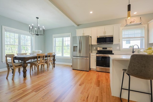 19 Millies Way, Sterling, MA 01564 - kitchen featuring stainless steel appliances, white cabinetry, light wood-style flooring, light countertops, and a chandelier
