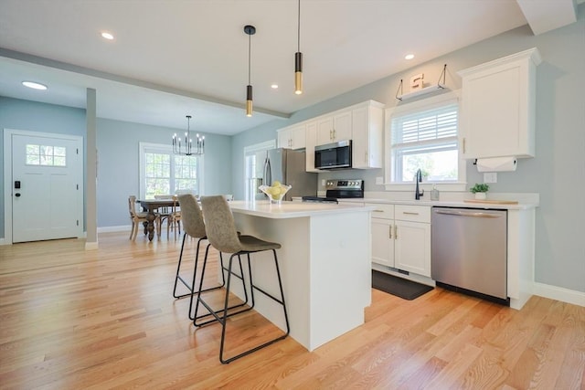 19 Millies Way, Sterling, MA 01564 - kitchen featuring appliances with stainless steel finishes, a breakfast bar area, white cabinetry, light wood finished floors, and recessed lighting