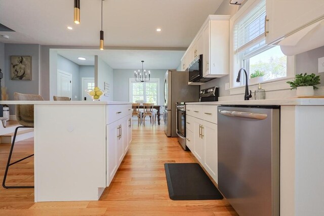 19 Millies Way, Sterling, MA 01564 - kitchen with appliances with stainless steel finishes, a center island, light wood finished floors, a chandelier, and a sink