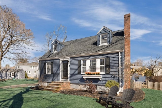 back of property with a shingled roof, a yard, fence, and a chimney