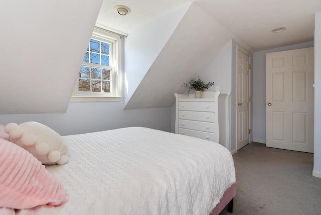 carpeted bedroom with lofted ceiling and baseboards