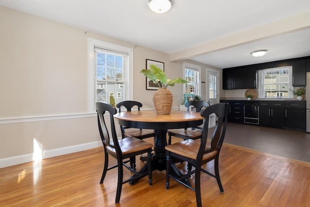 dining area with light wood-style flooring and baseboards