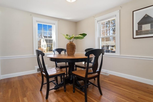 dining area with hardwood / wood-style flooring and baseboards