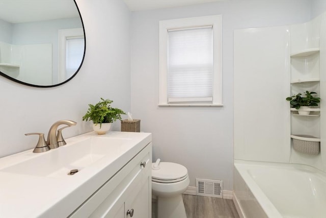 full bath featuring visible vents, toilet, wood finished floors, baseboards, and vanity