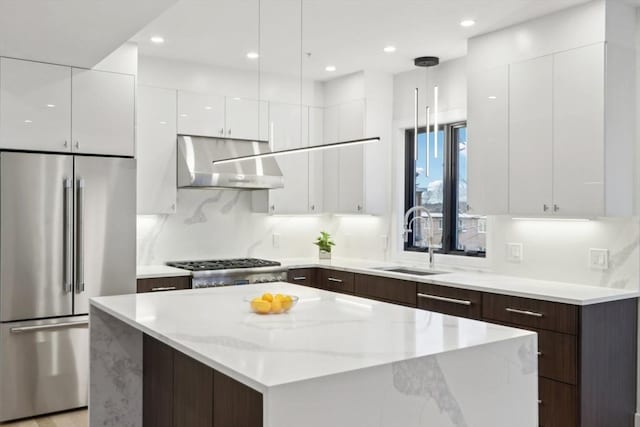 kitchen with dark brown cabinetry, sink, a kitchen island, and stainless steel appliances