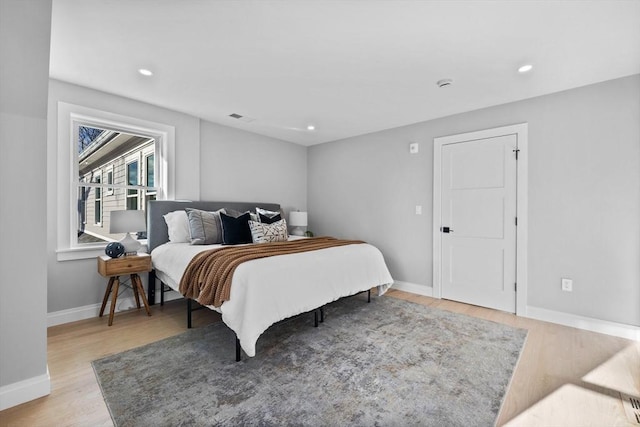 bedroom featuring light wood-type flooring, baseboards, visible vents, and recessed lighting