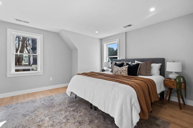 bedroom featuring wood finished floors, baseboards, and visible vents