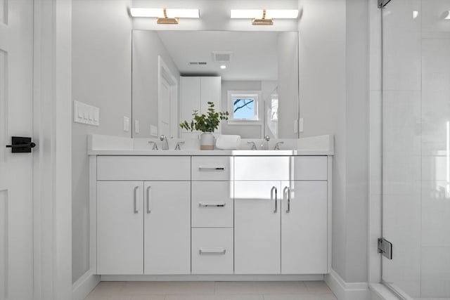bathroom featuring visible vents, a sink, double vanity, and a stall shower
