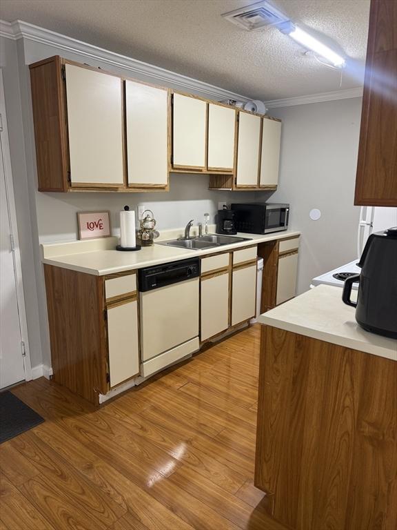 kitchen with dishwasher, sink, crown molding, light hardwood / wood-style flooring, and a textured ceiling