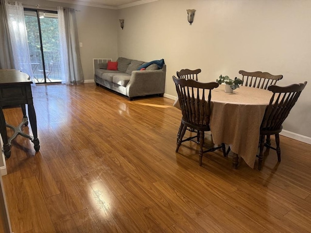 dining space with crown molding and hardwood / wood-style flooring