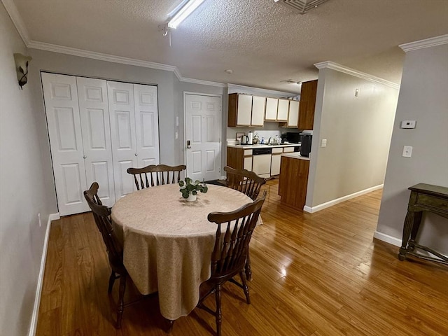 dining area with a textured ceiling, ornamental molding, and hardwood / wood-style floors