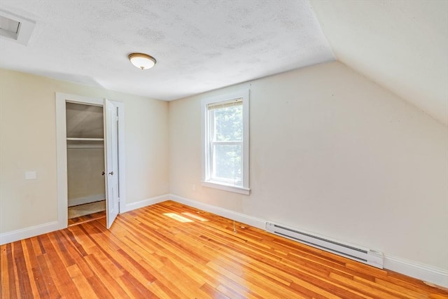 514 W Britannia St, Taunton, MA 02780 - unfurnished bedroom with baseboard heating, a closet, a textured ceiling, light wood finished floors, and lofted ceiling