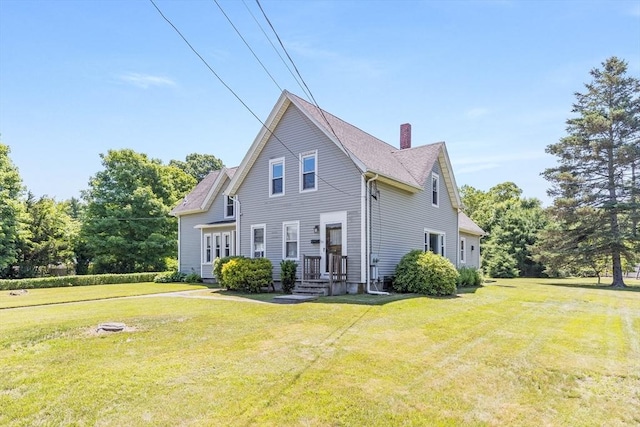 514 W Britannia St, Taunton, MA 02780 - view of front facade with a chimney and a front lawn