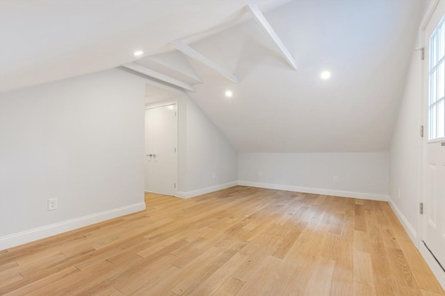 bonus room with light wood-type flooring, lofted ceiling, and baseboards