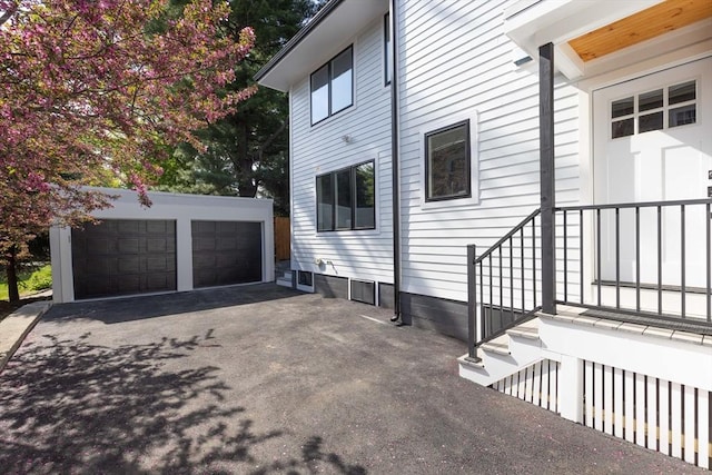 view of side of home featuring a garage and an outbuilding