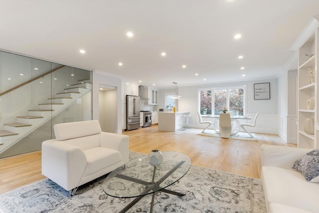 living room featuring ornamental molding, stairway, light wood-style flooring, and recessed lighting