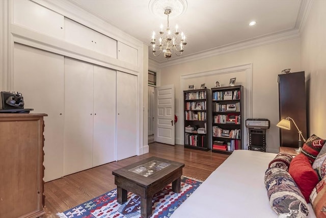 sitting room with dark hardwood / wood-style flooring, ornamental molding, and an inviting chandelier