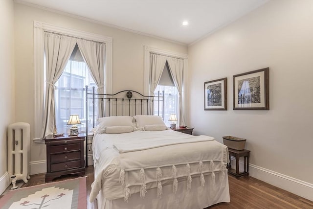 bedroom with radiator heating unit, crown molding, and dark wood-type flooring