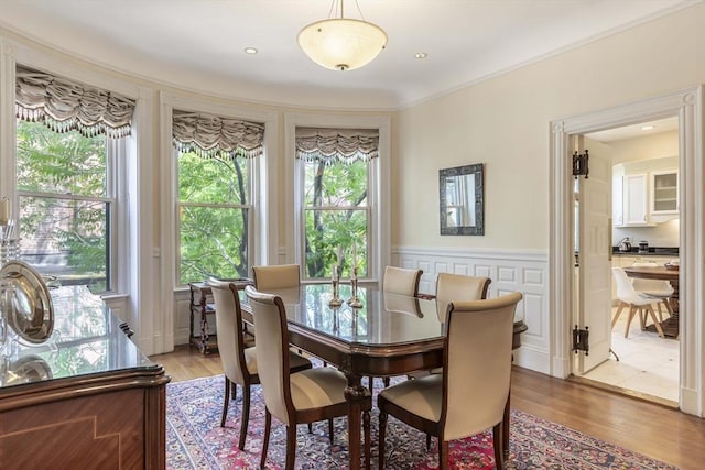 dining room with hardwood / wood-style flooring, a wealth of natural light, and crown molding