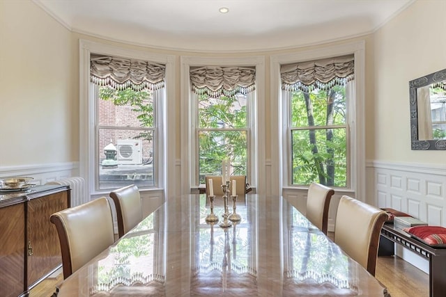 dining room with ornamental molding and light wood-type flooring