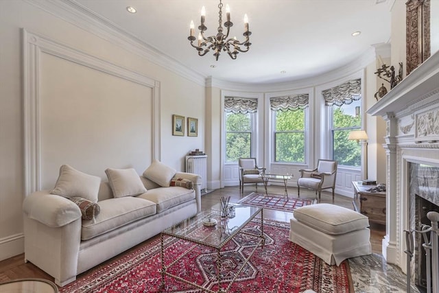 living room featuring a premium fireplace, crown molding, hardwood / wood-style floors, and an inviting chandelier