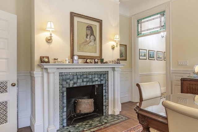 living area featuring hardwood / wood-style flooring, ornamental molding, and a fireplace