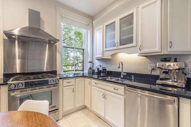 kitchen featuring white cabinetry, sink, wall chimney exhaust hood, dark stone countertops, and appliances with stainless steel finishes