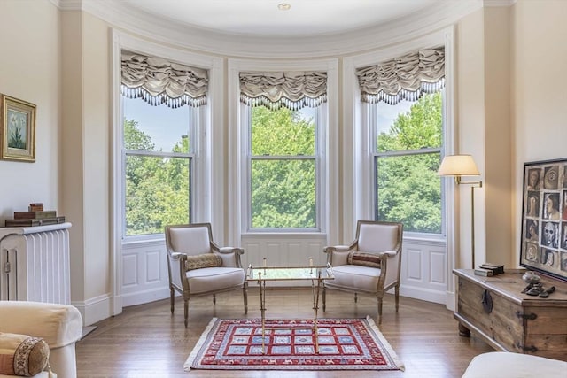 living area with dark hardwood / wood-style flooring, radiator heating unit, and ornamental molding