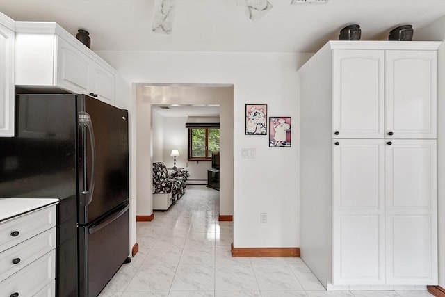 0 E Border Cir, Medford, MA 02155 - kitchen featuring freestanding refrigerator, light marble finish floors, baseboards, white cabinets, and a baseboard heating unit