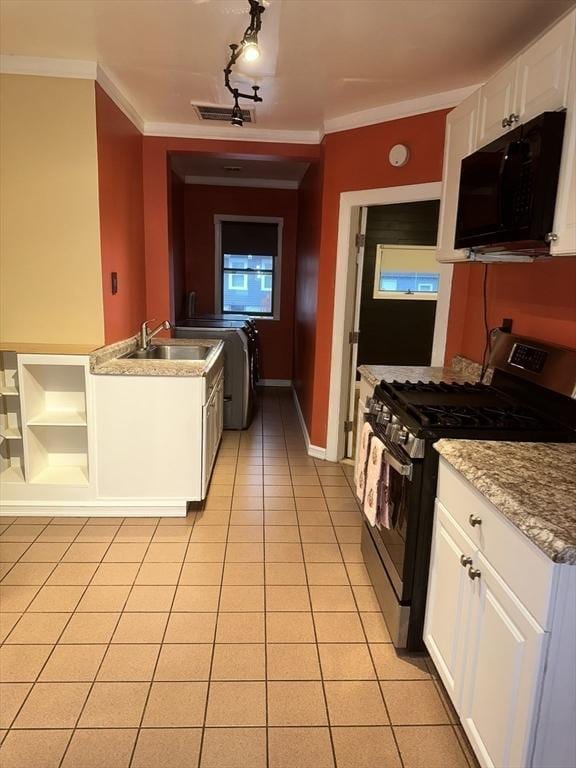 kitchen featuring white cabinetry, sink, stainless steel gas range oven, light tile patterned floors, and ornamental molding