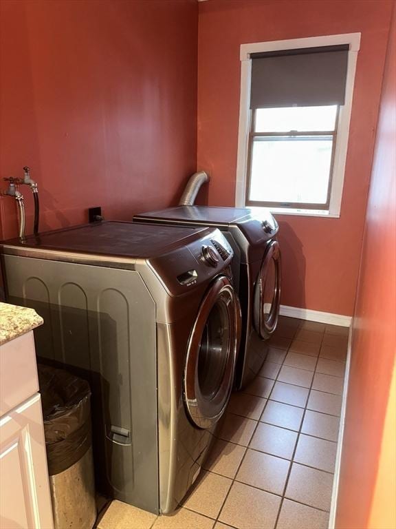 washroom with washing machine and clothes dryer and light tile patterned floors