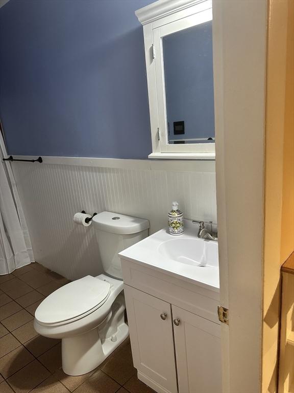 bathroom featuring tile patterned flooring, vanity, and toilet