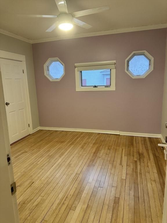 empty room featuring ceiling fan, light hardwood / wood-style floors, and ornamental molding