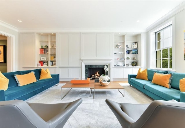 living area with crown molding, built in features, a fireplace, and wood finished floors