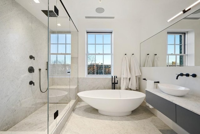 bathroom featuring a shower stall, a soaking tub, a healthy amount of sunlight, and tile walls