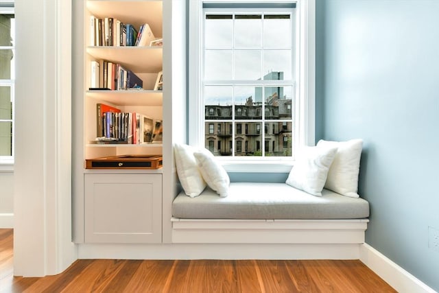 living area with baseboards and wood finished floors