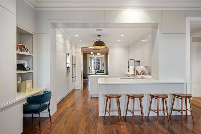 kitchen with white cabinetry, modern cabinets, a kitchen bar, and a sink