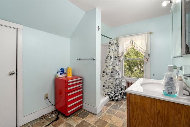 full bathroom with vanity, radiator, baseboards, and a stall shower