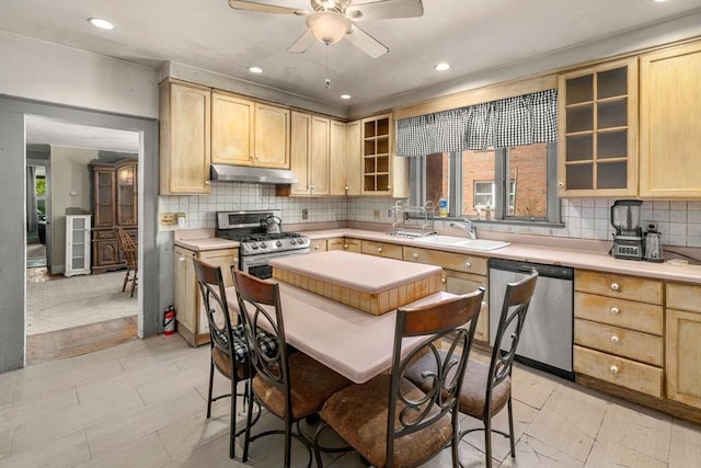 kitchen with a sink, under cabinet range hood, light brown cabinetry, and stainless steel appliances