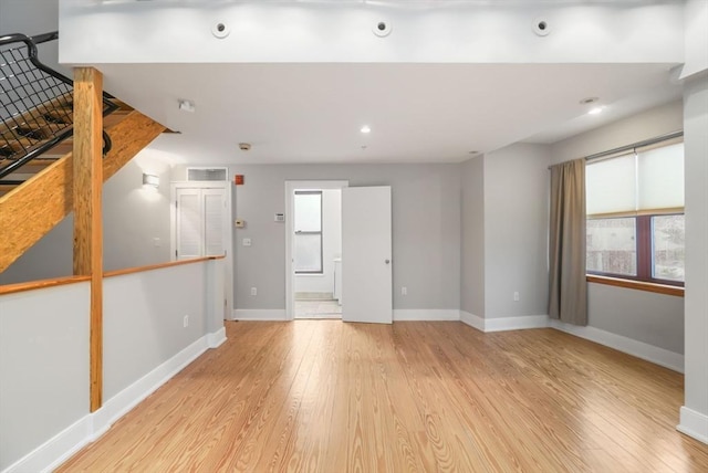 spare room with baseboards, plenty of natural light, and wood finished floors