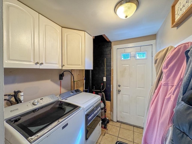 laundry area featuring light tile patterned floors, separate washer and dryer, and cabinet space