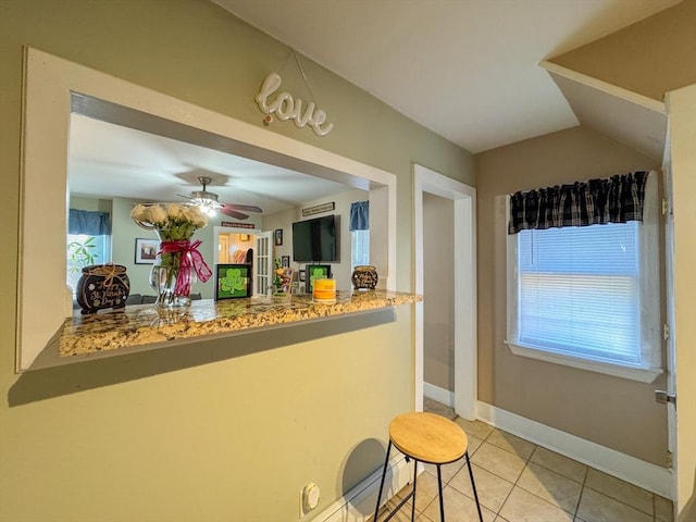 bar featuring ceiling fan, light tile patterned flooring, and baseboards