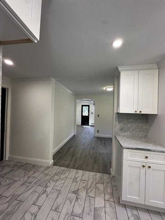 45 Carter Ave, Blackstone, MA 01504 - kitchen with white cabinetry, baseboards, light stone counters, recessed lighting, and crown molding