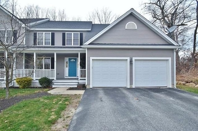view of front facade featuring a garage, driveway, and covered porch